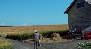 Movie still from “Dreams” (1990), directed by Akira Kurosawa – A man standing in front of a hay pile; Extreme Wide shot, High angle