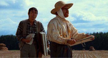 Movie still from “Dreams” (1990), directed by Akira Kurosawa – Two men standing next to each other in a field; Medium shot, Low angle