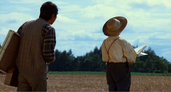 Movie still from “Dreams” (1990), directed by Akira Kurosawa – Two people standing in a field looking at trees; Wide shot, Over the shoulder angle