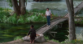 Movie still from “Dreams” (1990), directed by Akira Kurosawa – A woman and a child standing on a bridge over a body of water; Wide shot, High angle