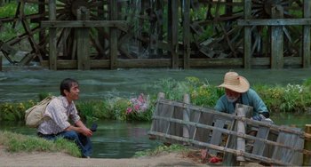 Movie still from “Dreams” (1990), directed by Akira Kurosawa – Two men sitting next to a body of water; Wide shot, High angle
