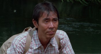 Movie still from “Dreams” (1990), directed by Akira Kurosawa – A man in a plaid shirt sitting next to a body of water; Close Up shot, High angle