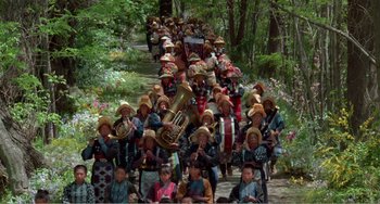Movie still from “Dreams” (1990), directed by Akira Kurosawa – A large group of people wearing hats marching down a road; Extreme Wide shot, High angle