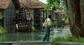 Movie still from “Dreams” (1990), directed by Akira Kurosawa – A man standing on a wooden platform near a river; Wide shot, Low angle