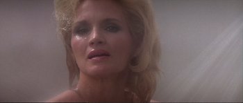 Movie still from “Dressed to Kill” (1980), directed by Brian De Palma – A woman's face in a bathroom; Close Up shot, Low angle