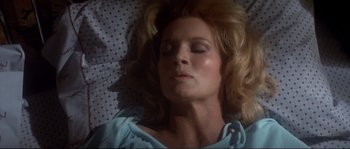 Movie still from “Dressed to Kill” (1980), directed by Brian De Palma – A woman laying in bed with her eyes closed; Close Up shot, Overhead angle