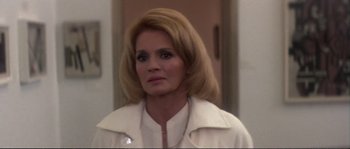 Movie still from “Dressed to Kill” (1980), directed by Brian De Palma – A person wearing a white jacket; Close Up shot, Over the shoulder angle