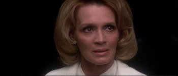 Movie still from “Dressed to Kill” (1980), directed by Brian De Palma – An older woman with blonde hair looking at the camera; Close Up shot, Low angle