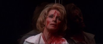 Movie still from “Dressed to Kill” (1980), directed by Brian De Palma – A woman with blood all over her face and neck; Close Up shot, High angle