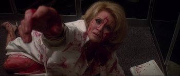 Movie still from “Dressed to Kill” (1980), directed by Brian De Palma – A woman with blood all over her face; Close Up shot, High angle
