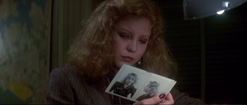 Movie still from “Dressed to Kill” (1980), directed by Brian De Palma – A woman looking at an old picture of herself; Close Up shot, Over the shoulder angle