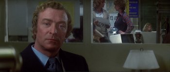 Movie still from “Dressed to Kill” (1980), directed by Brian De Palma – A person in a room near a window; Close Up shot, Over the shoulder angle