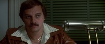 Movie still from “Dressed to Kill” (1980), directed by Brian De Palma – A person wearing a brown leather jacket; Close Up shot, High angle