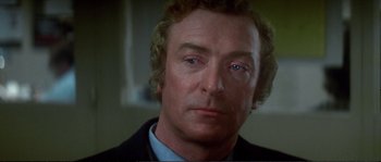 Movie still from “Dressed to Kill” (1980), directed by Brian De Palma – A person wearing a suit and tie; Close Up shot, Over the shoulder angle