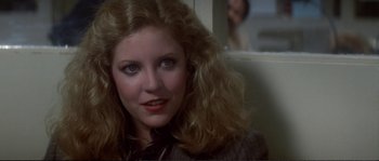 Movie still from “Dressed to Kill” (1980), directed by Brian De Palma – A person with long hair; Close Up shot, Over the shoulder angle