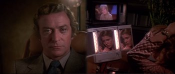 Movie still from “Dressed to Kill” (1980), directed by Brian De Palma – A television screen with a man and a woman on it; Close Up shot, Over the shoulder angle