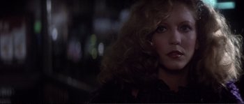 Movie still from “Dressed to Kill” (1980), directed by Brian De Palma – A person with curly hair; Close Up shot, Over the shoulder angle