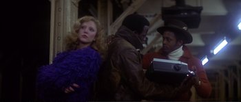 Movie still from “Dressed to Kill” (1980), directed by Brian De Palma – A man and a woman standing next to each other in a room; Medium shot, Over the shoulder angle