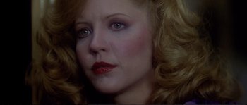 Movie still from “Dressed to Kill” (1980), directed by Brian De Palma – A person with blonde hair and blue eyes; Close Up shot, Over the shoulder angle