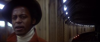 Movie still from “Dressed to Kill” (1980), directed by Brian De Palma – A person standing in front of a wall with lights on it; Close Up shot, Low angle