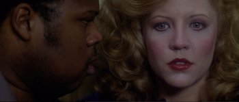 Movie still from “Dressed to Kill” (1980), directed by Brian De Palma – Two people with one of them kissing; Close Up shot, Over the shoulder angle