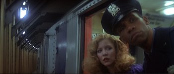 Movie still from “Dressed to Kill” (1980), directed by Brian De Palma – A woman with red hair and a police officer in a uniform; Close Up shot, Low angle
