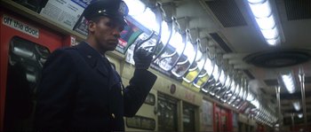 Movie still from “Dressed to Kill” (1980), directed by Brian De Palma – A man in a police uniform standing on a train platform; Close Up shot, Low angle