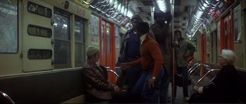 Movie still from “Dressed to Kill” (1980), directed by Brian De Palma – A group of people riding on a subway train; Wide shot, High angle