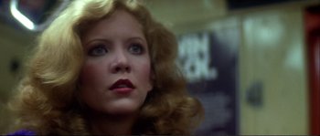 Movie still from “Dressed to Kill” (1980), directed by Brian De Palma – A person with curly hair; Close Up shot, Low angle