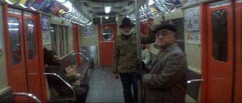 Movie still from “Dressed to Kill” (1980), directed by Brian De Palma – Two older men riding on a subway train; Wide shot, High angle