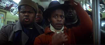 Movie still from “Dressed to Kill” (1980), directed by Brian De Palma – A group of men standing next to each other on a train; Close Up shot, Low angle