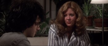 Movie still from “Dressed to Kill” (1980), directed by Brian De Palma – A man and a woman sitting on a couch; Medium shot, Over the shoulder angle