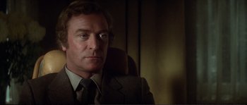 Movie still from “Dressed to Kill” (1980), directed by Brian De Palma – A person wearing a suit and tie; Close Up shot, Low angle