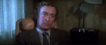 Movie still from “Dressed to Kill” (1980), directed by Brian De Palma – A person wearing a suit and tie; Close Up shot, High angle