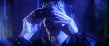Movie still from “Dressed to Kill” (1980), directed by Brian De Palma – A person holding a camera up to their face; Close Up shot, Over the shoulder angle
