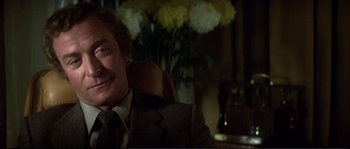 Movie still from “Dressed to Kill” (1980), directed by Brian De Palma – A person wearing a suit and tie; Close Up shot, Low angle