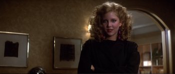 Movie still from “Dressed to Kill” (1980), directed by Brian De Palma – A young woman in a black shirt is posing for a picture; Close Up shot, Low angle