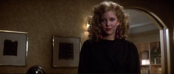 Movie still from “Dressed to Kill” (1980), directed by Brian De Palma – A young woman in a black jacket and pink earrings; Close Up shot, Low angle