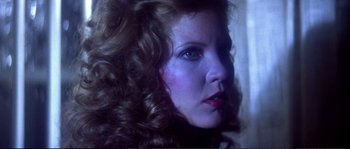 Movie still from “Dressed to Kill” (1980), directed by Brian De Palma – A person with curly hair; Close Up shot, Low angle