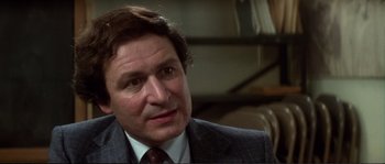 Movie still from “Dressed to Kill” (1980), directed by Brian De Palma – A person wearing a suit and tie; Close Up shot, Over the shoulder angle