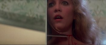 Movie still from “Dressed to Kill” (1980), directed by Brian De Palma – A woman looking into a bathroom mirror with blood on her face; Close Up shot, Low angle