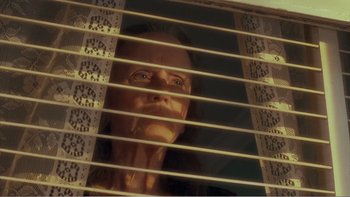 Movie still from “Driving Miss Daisy” (1989), directed by Bruce Beresford – An older woman looking out of a window through blinds; Close Up shot, Low angle