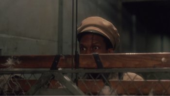 Movie still from “Driving Miss Daisy” (1989), directed by Bruce Beresford – A man in a tan hat looking over a fence; Close Up shot, High angle