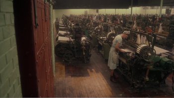 Movie still from “Driving Miss Daisy” (1989), directed by Bruce Beresford – An older woman working in an old fashioned machine shop; Wide shot, High angle