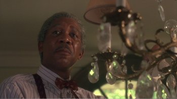 Movie still from “Driving Miss Daisy” (1989), directed by Bruce Beresford – An older man standing in front of a chandelier; Close Up shot, Low angle