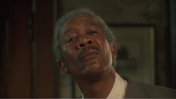 Movie still from “Driving Miss Daisy” (1989), directed by Bruce Beresford – An older man with grey hair is looking up; Close Up shot, Low angle