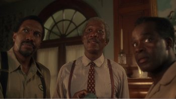Movie still from “Driving Miss Daisy” (1989), directed by Bruce Beresford – Two men and a woman standing next to each other in a room; Medium shot, Low angle