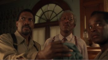 Movie still from “Driving Miss Daisy” (1989), directed by Bruce Beresford – Two men standing next to each other in front of an arch window; Close Up shot, Low angle