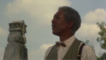 Movie still from “Driving Miss Daisy” (1989), directed by Bruce Beresford – An older man wearing a vest and bow tie looking up; Close Up shot, Low angle