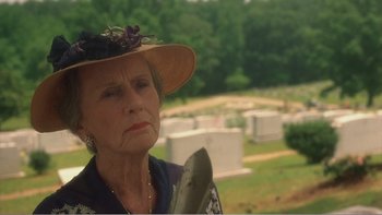 Movie still from “Driving Miss Daisy” (1989), directed by Bruce Beresford – An older woman wearing a hat and holding a shovel; Close Up shot, Over the shoulder angle
